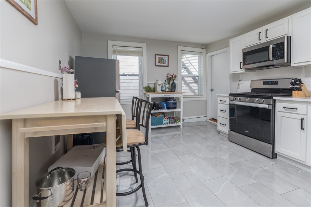 69 I Street, Unit 3 Boston, MA 02127 - Photo 7 of 14 a kitchen with a stove a sink and a microwave