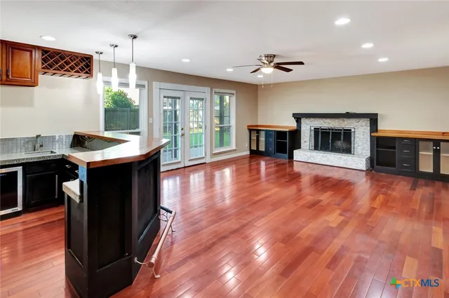a view of an empty room with window and wooden floor