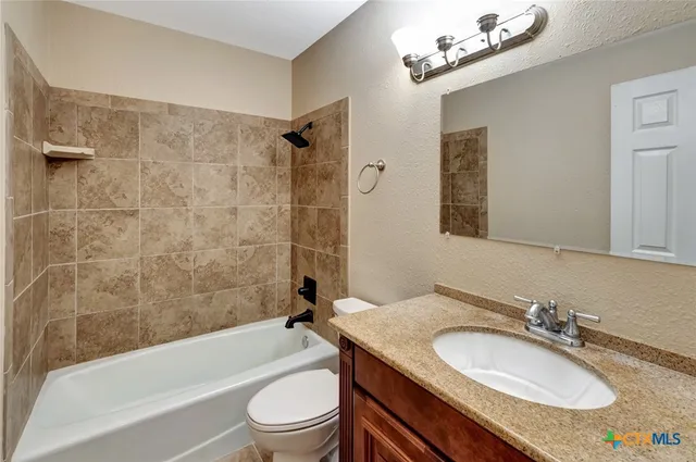 an empty room with closet and a ceiling fan