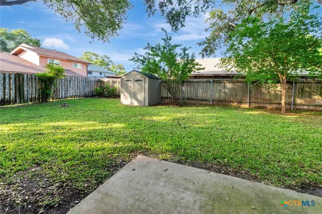 a view of backyard with a garden and trees