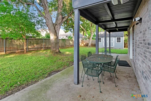 a view of a porch with a table chairs and a yard