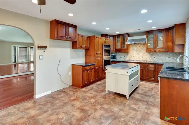 a kitchen with a stove sink and cabinets