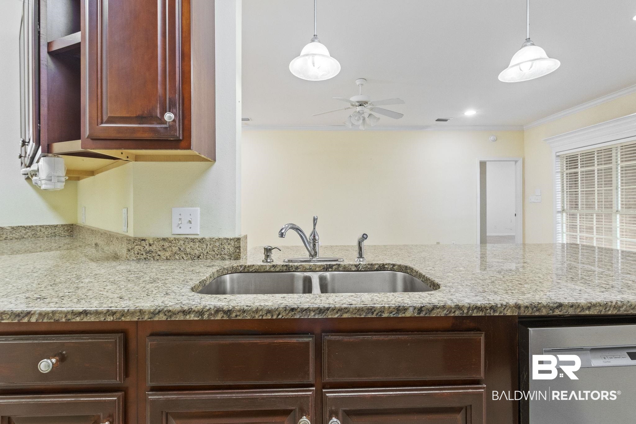 166 Club Drive Fairhope, AL 36532 - Photo 14 of 41 Kitchen with hanging light fixtures, light stone counters, sink, ceiling fan, and ornamental molding