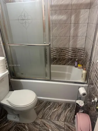 a bathroom with a toilet and a shower