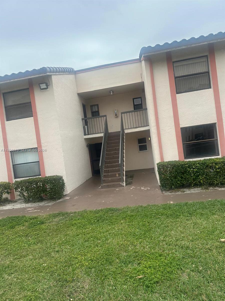 855 Northeast 209th Street, Unit 20334 Miami, FL 33179 - Photo 2 of 17 a front view of a house with a yard and garage