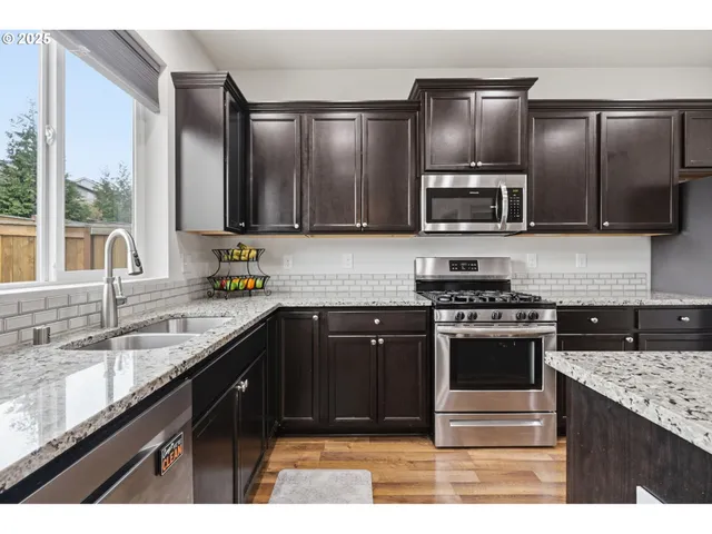 a kitchen with kitchen island granite countertop stainless steel appliances and sink