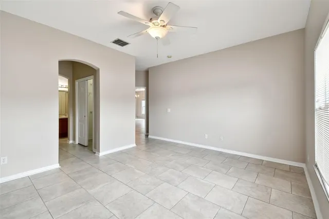 an empty room with a window and a fan