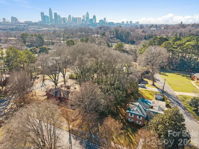 an aerial view of residential houses with outdoor space and trees