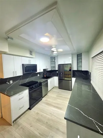 a kitchen with stainless steel appliances granite countertop a stove a sink and a refrigerator