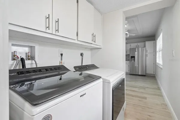 a kitchen with white cabinets and appliances