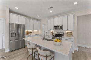 2760 River Meadow Spring Hope, NC 27882 - Photo 3 of 42 a kitchen with stainless steel appliances a refrigerator a stove a sink a dining table and chairs