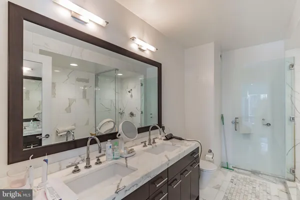 a bathroom with a double vanity sink mirror and shower