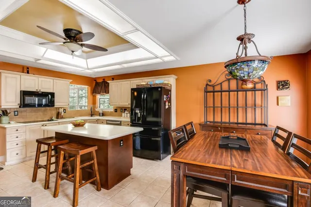 a dining hall with stainless steel appliances granite countertop a stove and a dining table