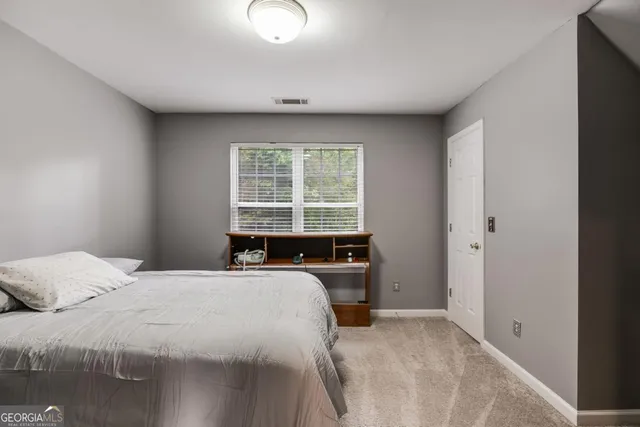 a bedroom with a bed and a large window