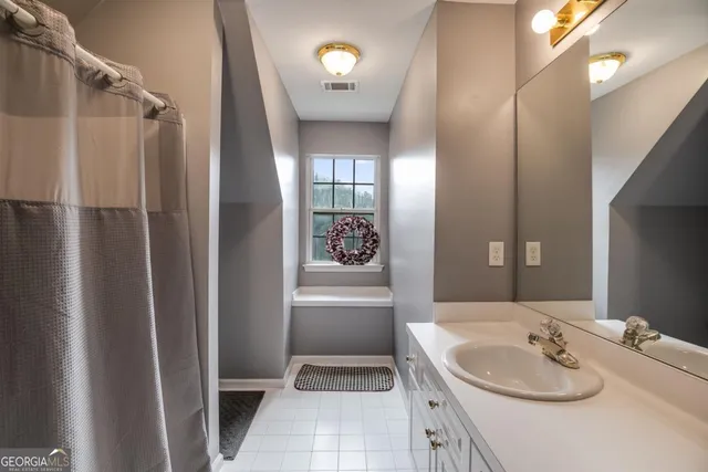 a bathroom with a tub sink and mirror
