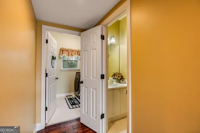 a view of a hallway with wooden floor and closet