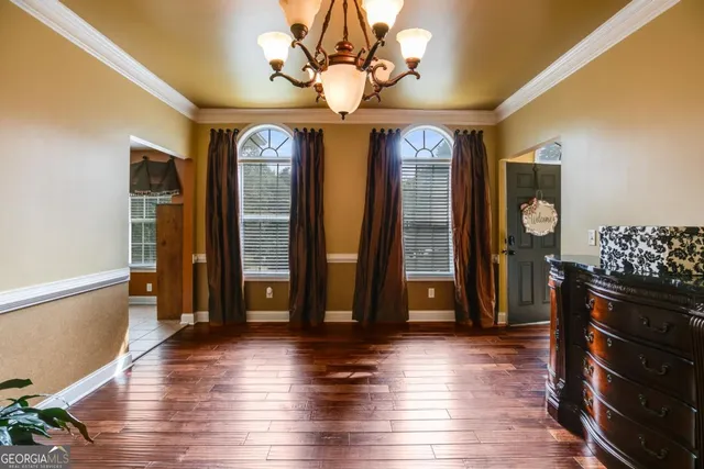 a view of a room with wooden floor and lots of windows
