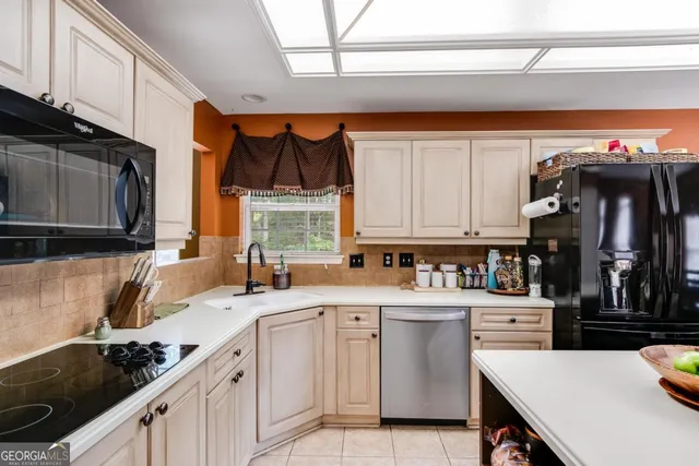 a kitchen with white cabinets and appliances