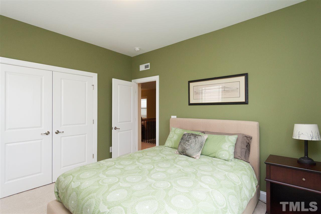 1410 Van Page Boulevard Raleigh, NC 27607 - Photo 20 of 25 a large bed in a bedroom next to a lamp