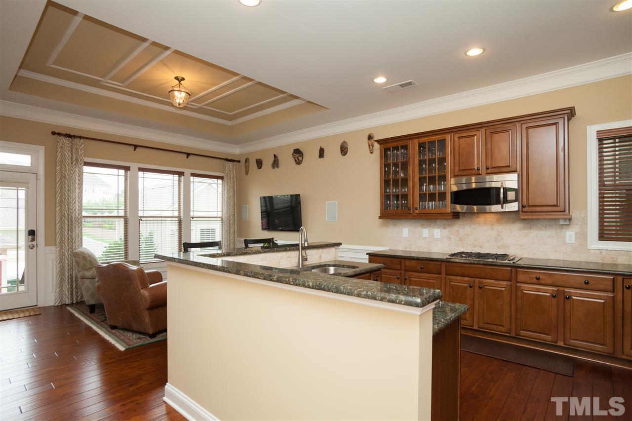 1410 Van Page Boulevard Raleigh, NC 27607 - Photo 8 of 25 a view of a kitchen with kitchen island a large window cabinets a sink and a counter top space
