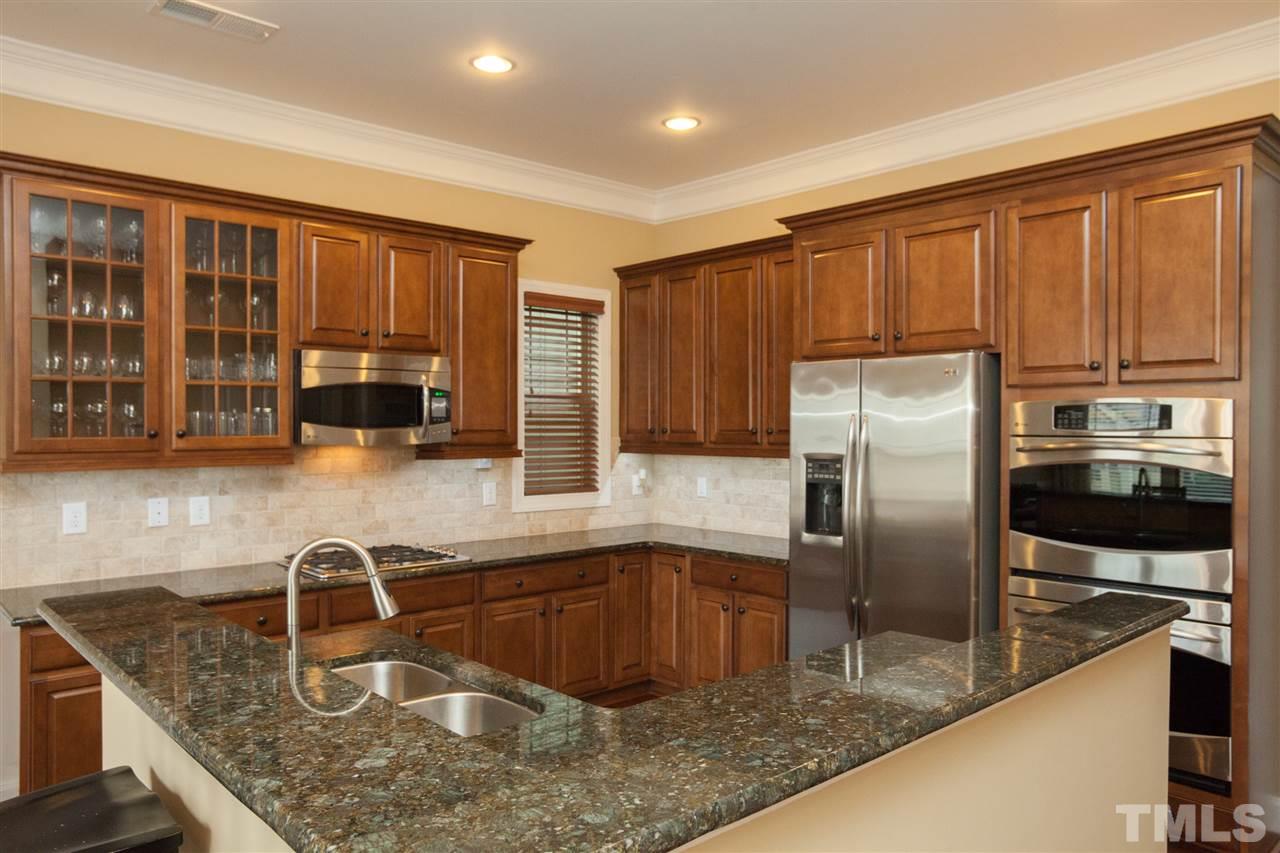 1410 Van Page Boulevard Raleigh, NC 27607 - Photo 9 of 25 a kitchen with stainless steel appliances granite countertop a sink refrigerator and cabinets