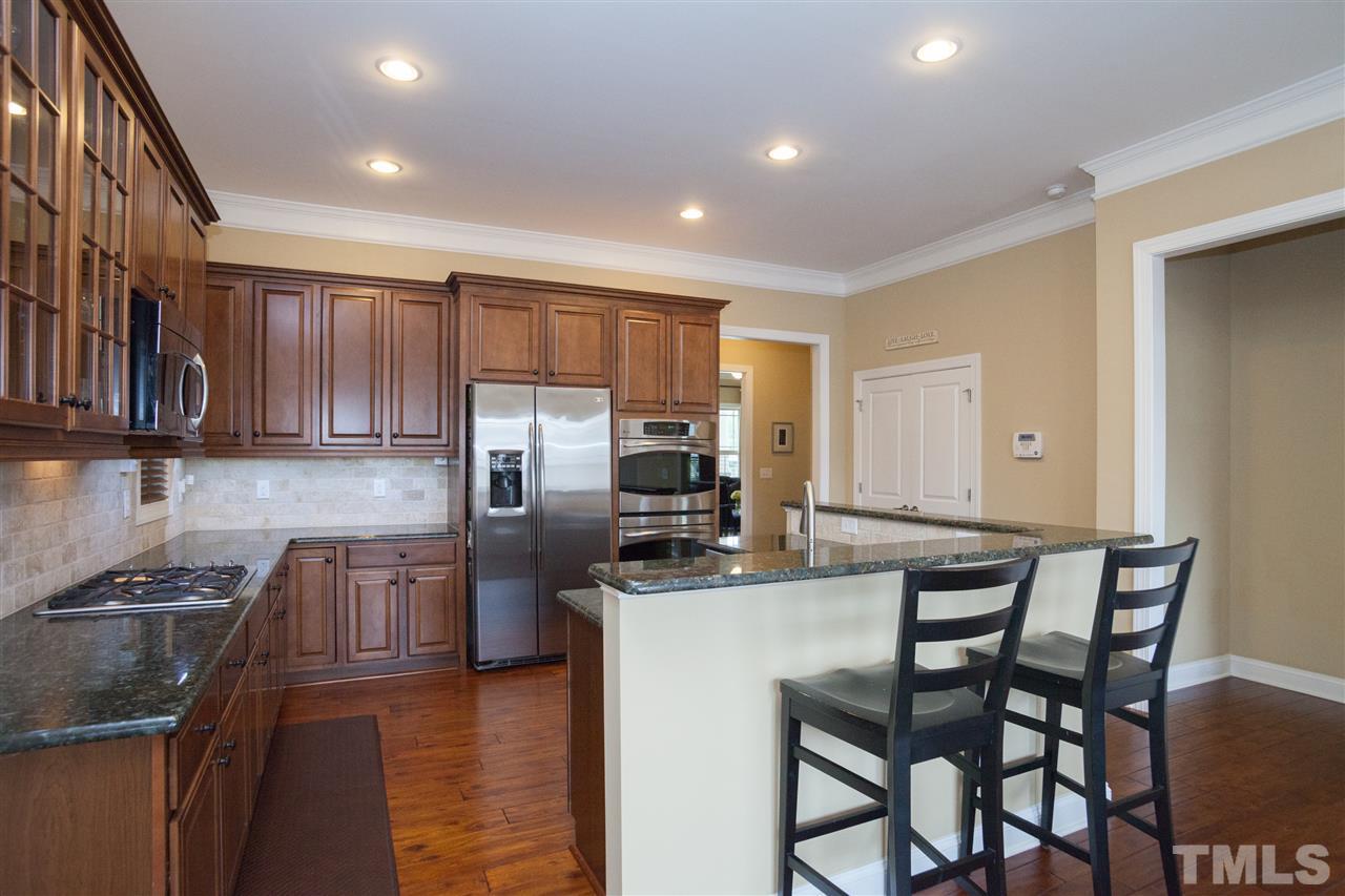 1410 Van Page Boulevard Raleigh, NC 27607 - Photo 10 of 25 a kitchen with stainless steel appliances granite countertop a stove top oven a sink a refrigerator and chairs