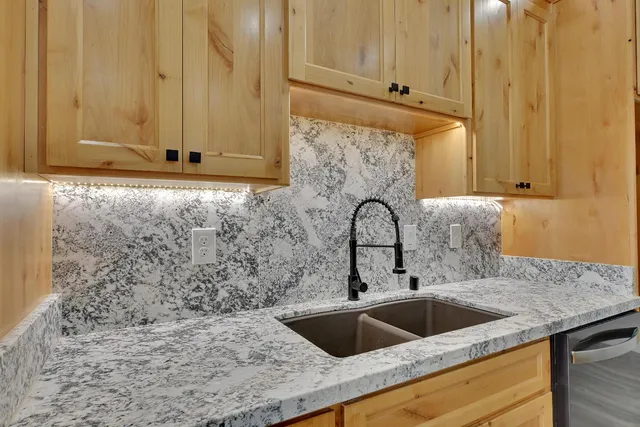 a kitchen with granite countertop a sink and cabinets