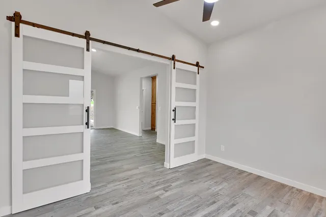 an empty room with wooden floor and window