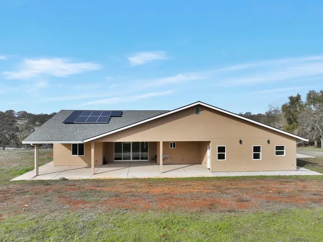 a view of a dry yard with wooden fence