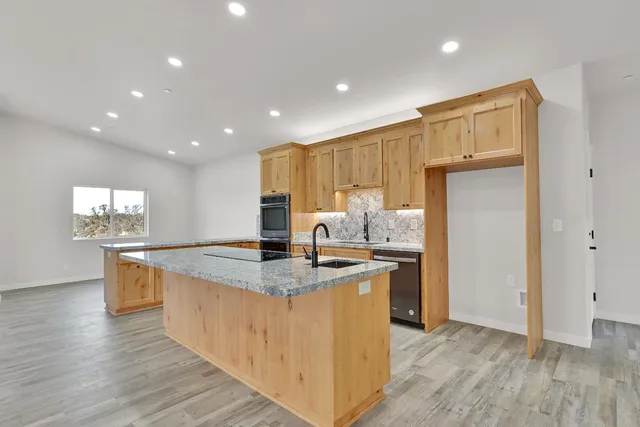 a kitchen with stainless steel appliances granite countertop a sink stove and refrigerator