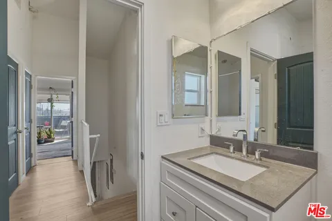 a en suite bathroom with a granite countertop sink and a mirror