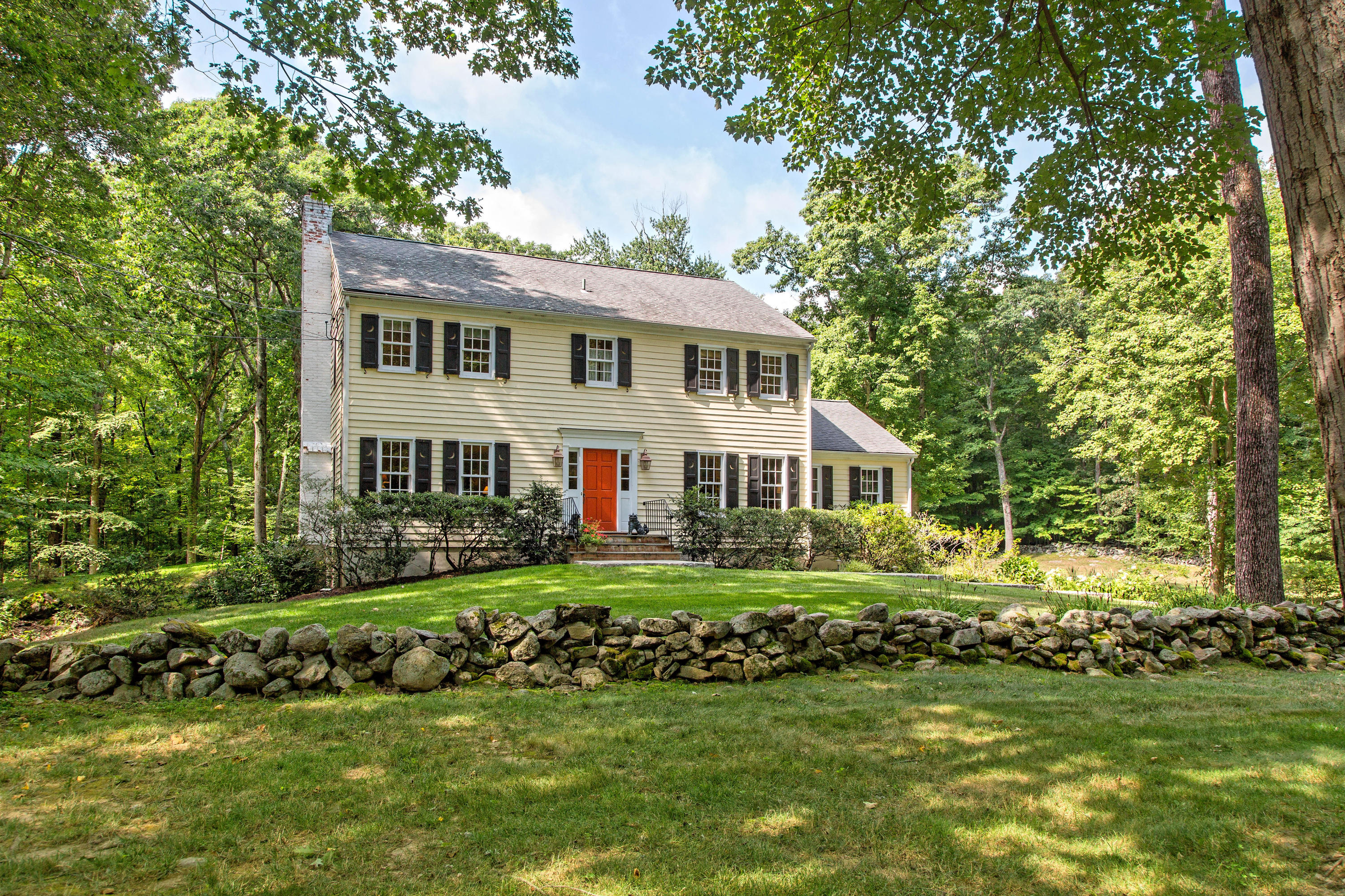 292 Briscoe Road New Canaan, CT 06840 - Photo 1 of 45 a front view of a house with a garden