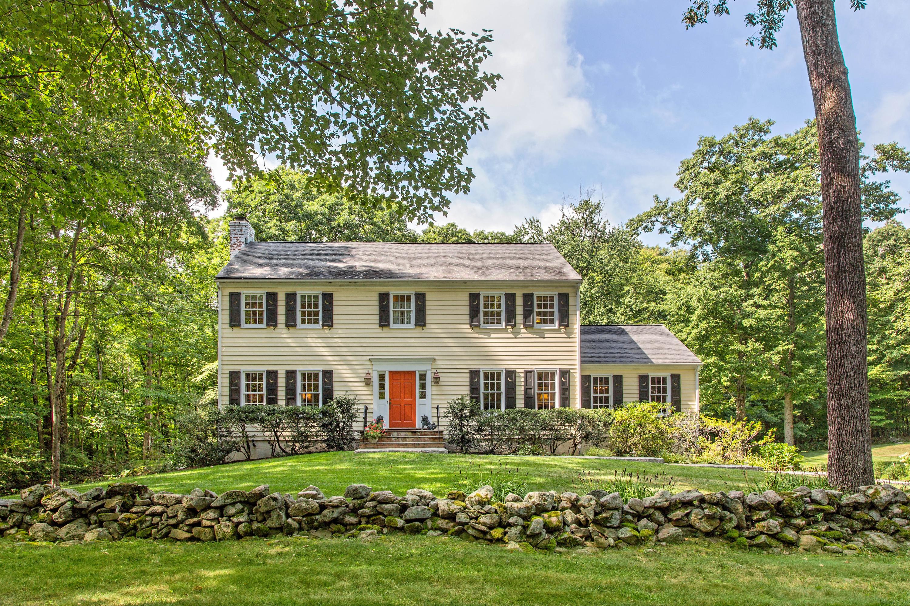 292 Briscoe Road New Canaan, CT 06840 - Photo 2 of 45 a front view of a house with a garden