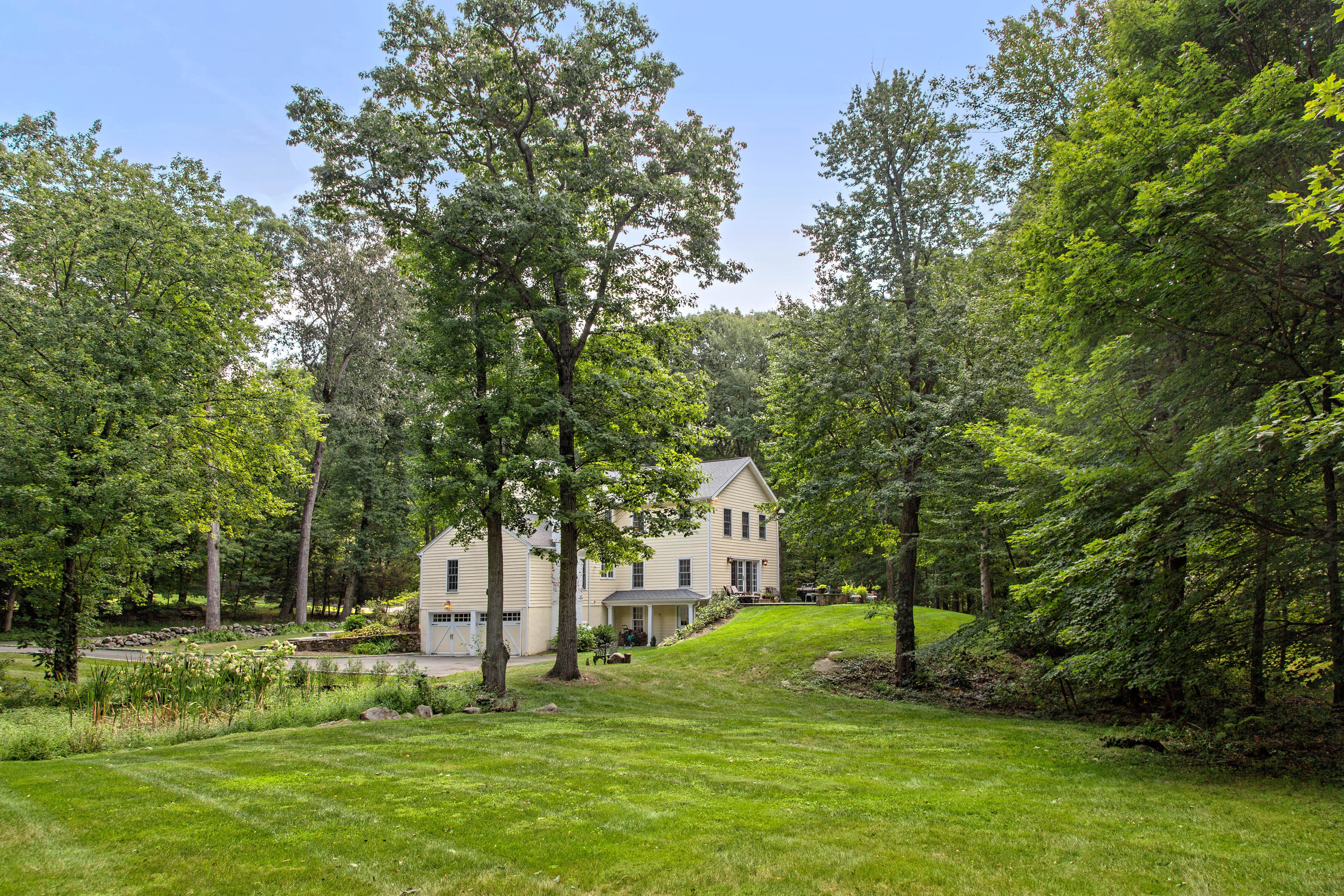 292 Briscoe Road New Canaan, CT 06840 - Photo 3 of 45 a garden with trees in front of it