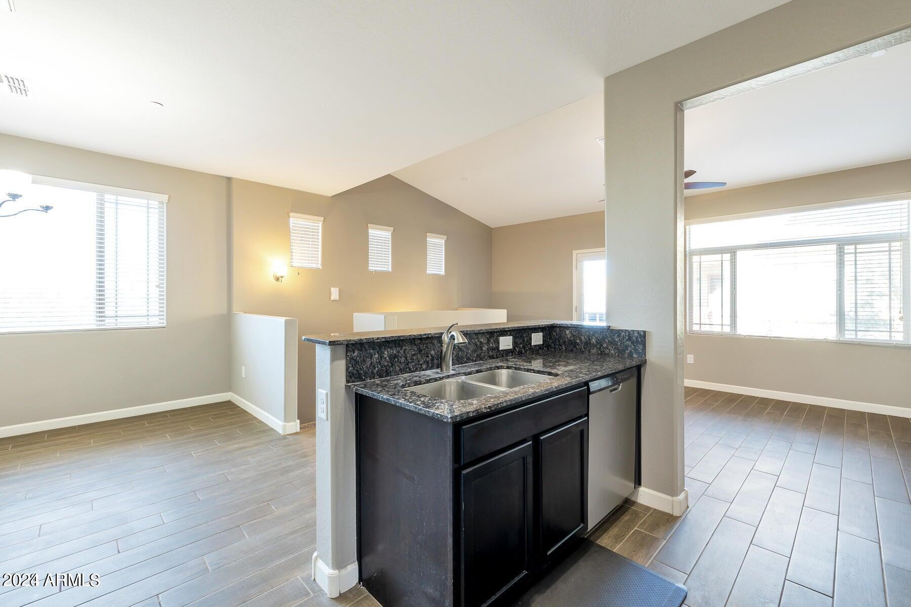 2150 West Alameda Road, Unit 1169 Phoenix, AZ 85085 - Photo 21 of 26 a kitchen with granite countertop a sink and a stove top oven