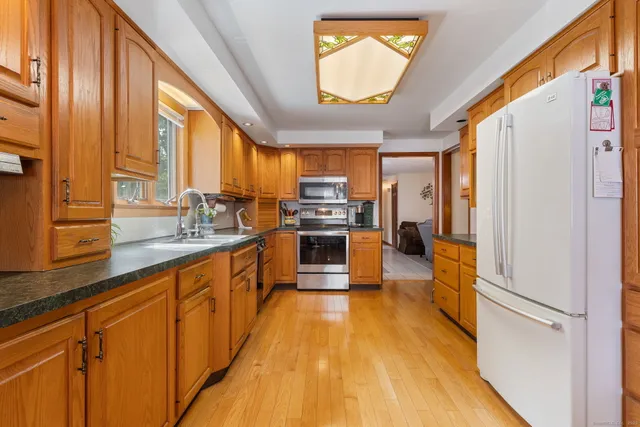 a large kitchen with stainless steel appliances a large window and a refrigerator