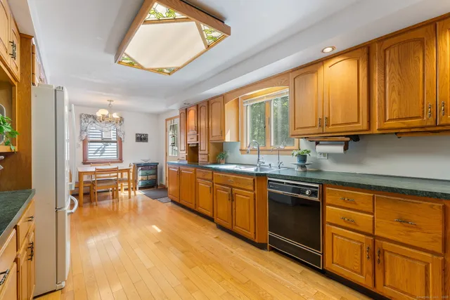 a kitchen with stainless steel appliances granite countertop sink stove and wooden cabinets
