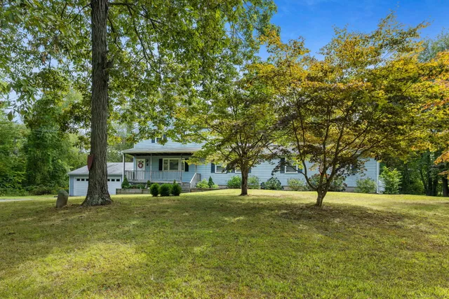 a view of a house with a big yard and palm trees