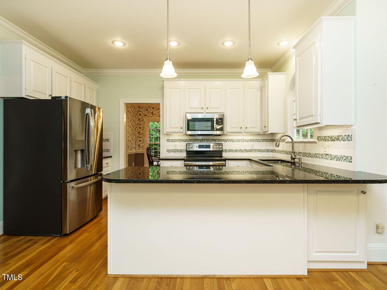 7201 Jonathan Drive Wendell, NC 27591 - Photo 12 of 43 a view of kitchen with stainless steel appliances kitchen island wooden floor and window