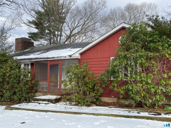 a front view of a house with a yard and potted plants
