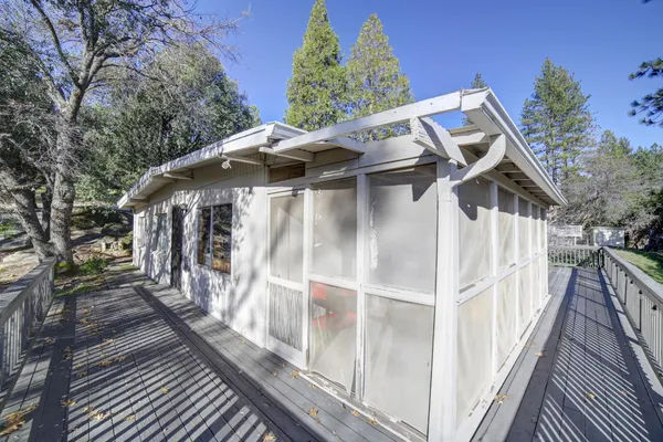 a view of a house with wooden deck front of house