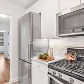 a kitchen with a stove and a wooden floor