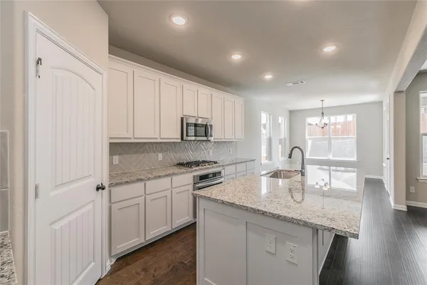 a kitchen with granite countertop white cabinets and white appliances