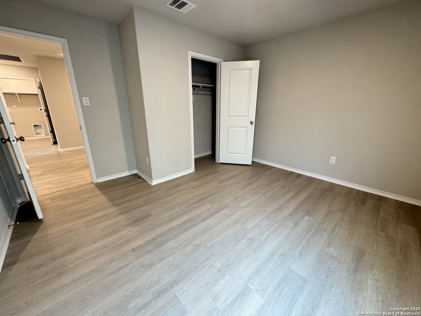 5523 Basil Chase St. Hedwig, TX 78152 - Photo 11 of 15 an empty room with wooden floor and mirror