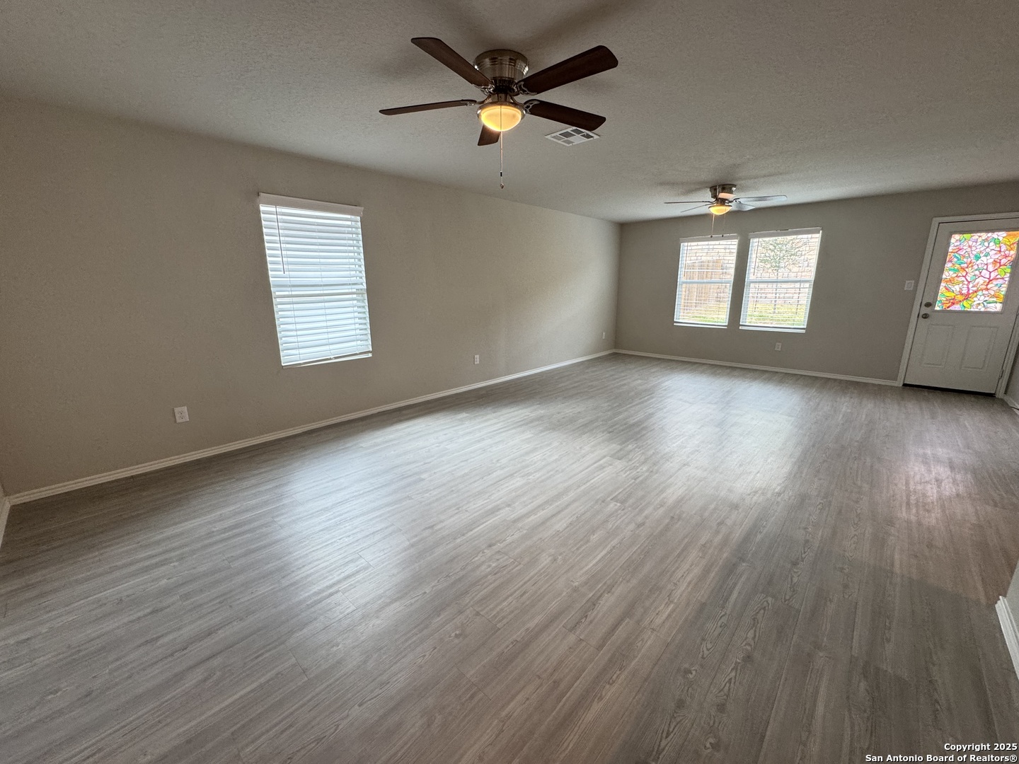 5523 Basil Chase St. Hedwig, TX 78152 - Photo 2 of 15 a view of room with window ceiling fan and hardwood floor