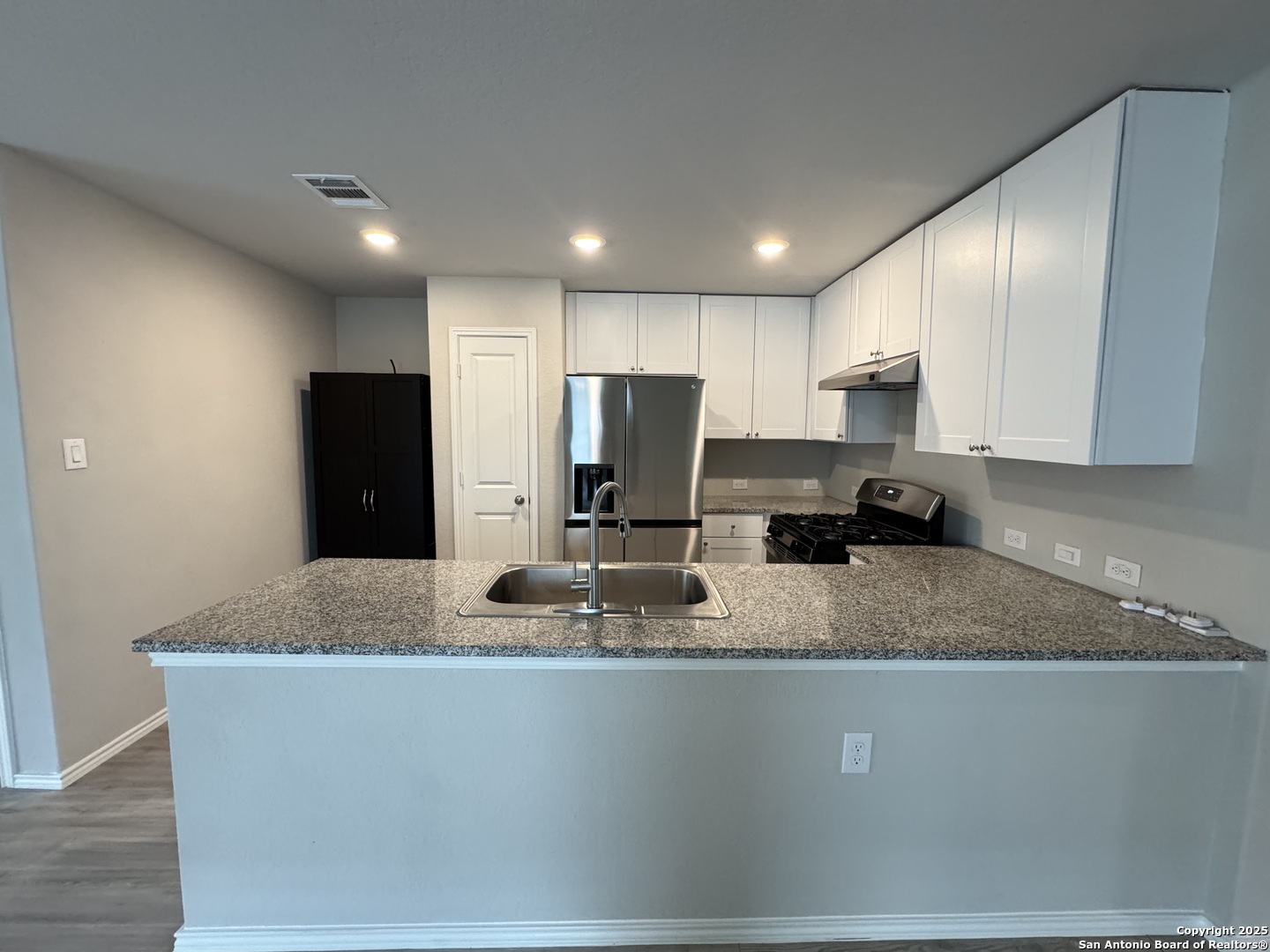 5523 Basil Chase St. Hedwig, TX 78152 - Photo 3 of 15 a kitchen with stainless steel appliances granite countertop a sink a refrigerator and a granite counter tops