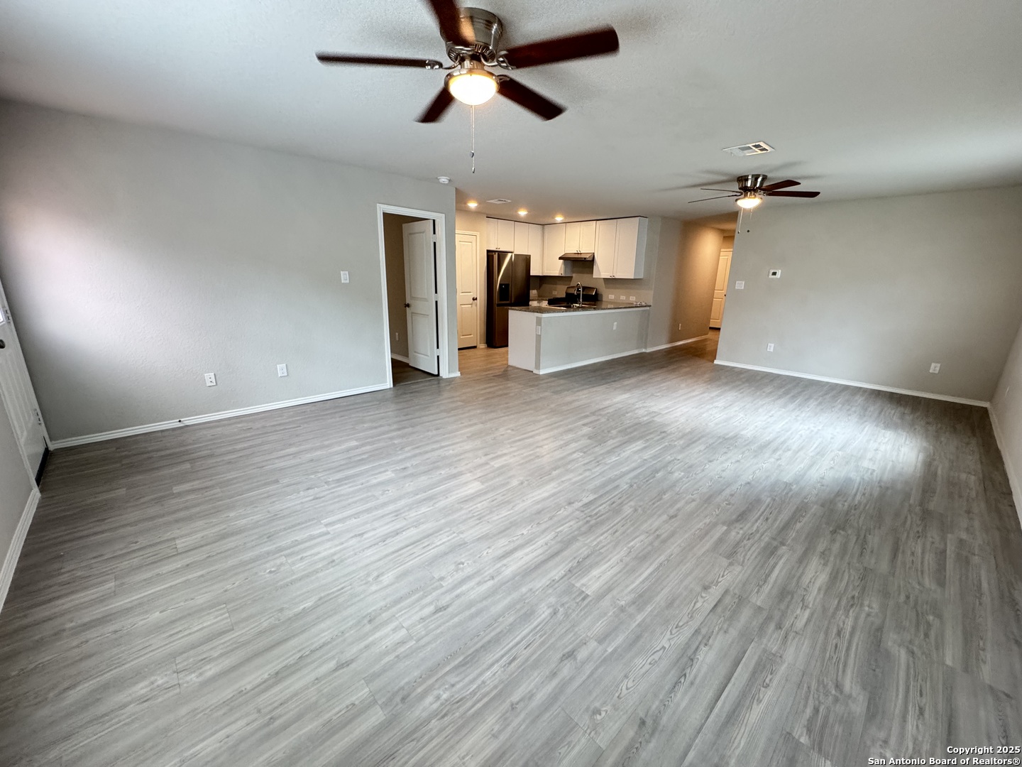 5523 Basil Chase St. Hedwig, TX 78152 - Photo 4 of 15 an empty room with wooden floor ceiling fan and windows