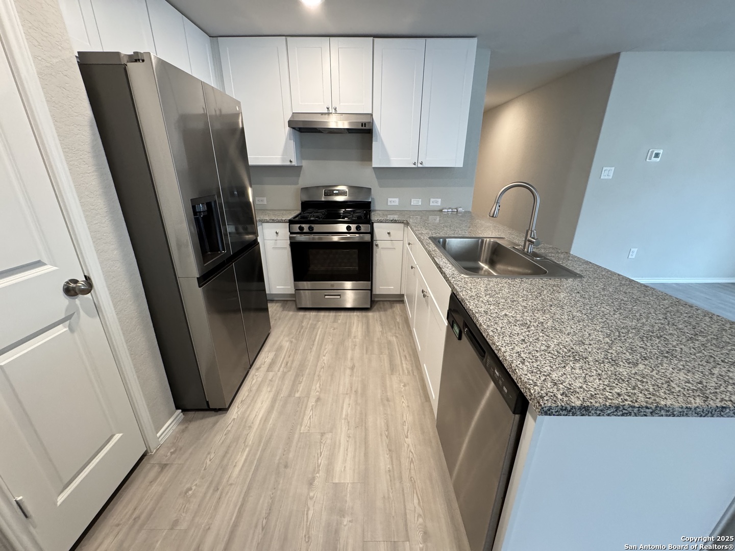 5523 Basil Chase St. Hedwig, TX 78152 - Photo 5 of 15 a kitchen with granite countertop a refrigerator a sink a stove and dishwasher