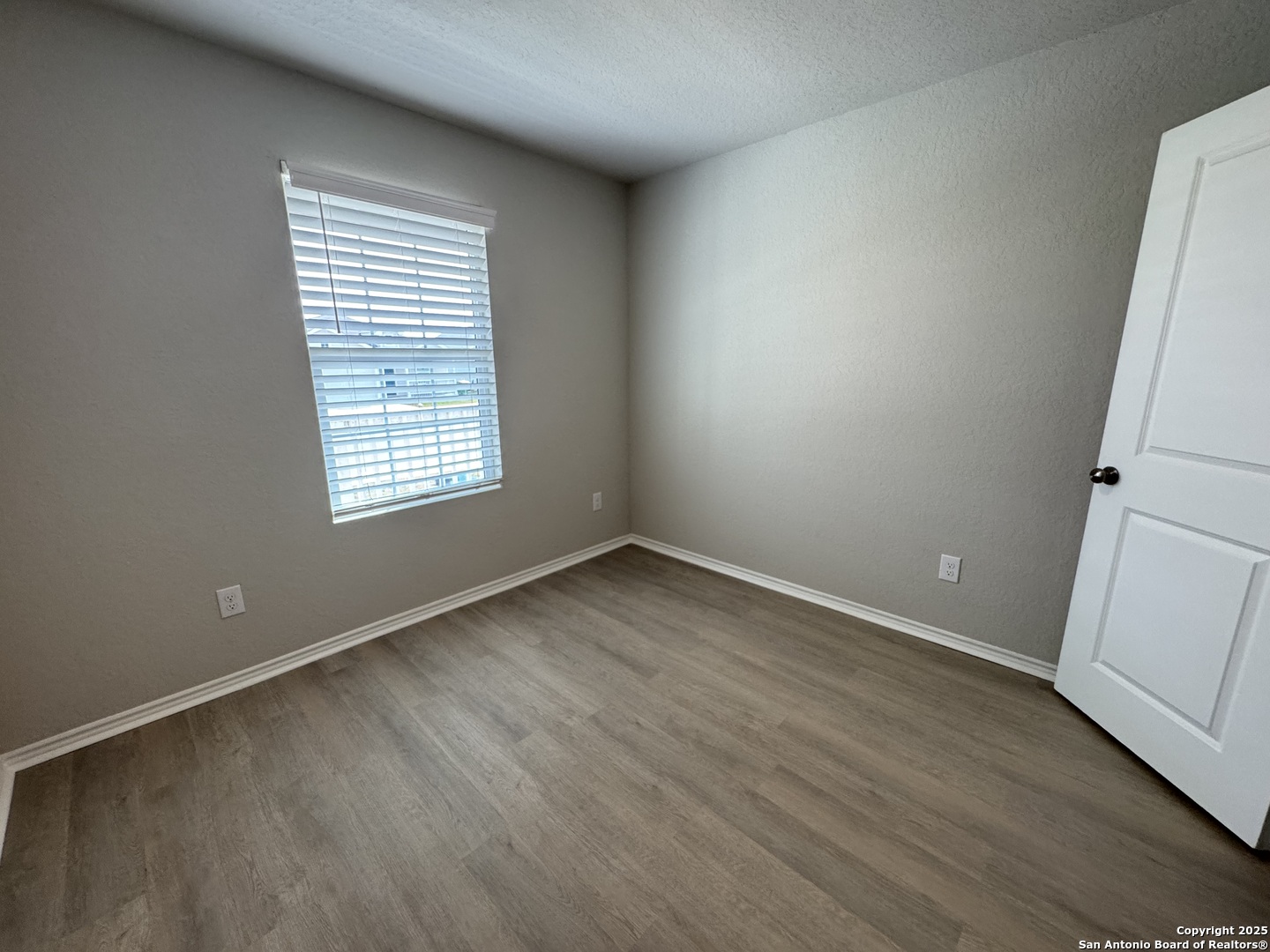 5523 Basil Chase St. Hedwig, TX 78152 - Photo 9 of 15 an empty room with wooden floor and window