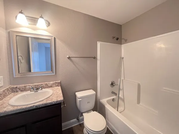 a bathroom with a sink toilet vanity and shower